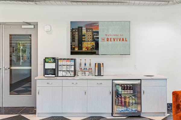 A white fridge with a glass door is in front of a white counter. at The Revival, Salt Lake City, 84101